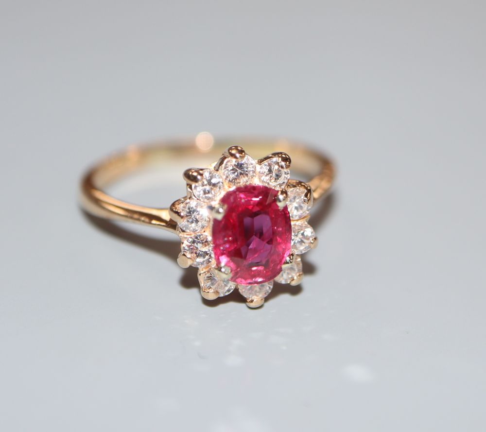 An 18k, ruby and diamond set oval cluster ring, size L, gross 2.9 grams.